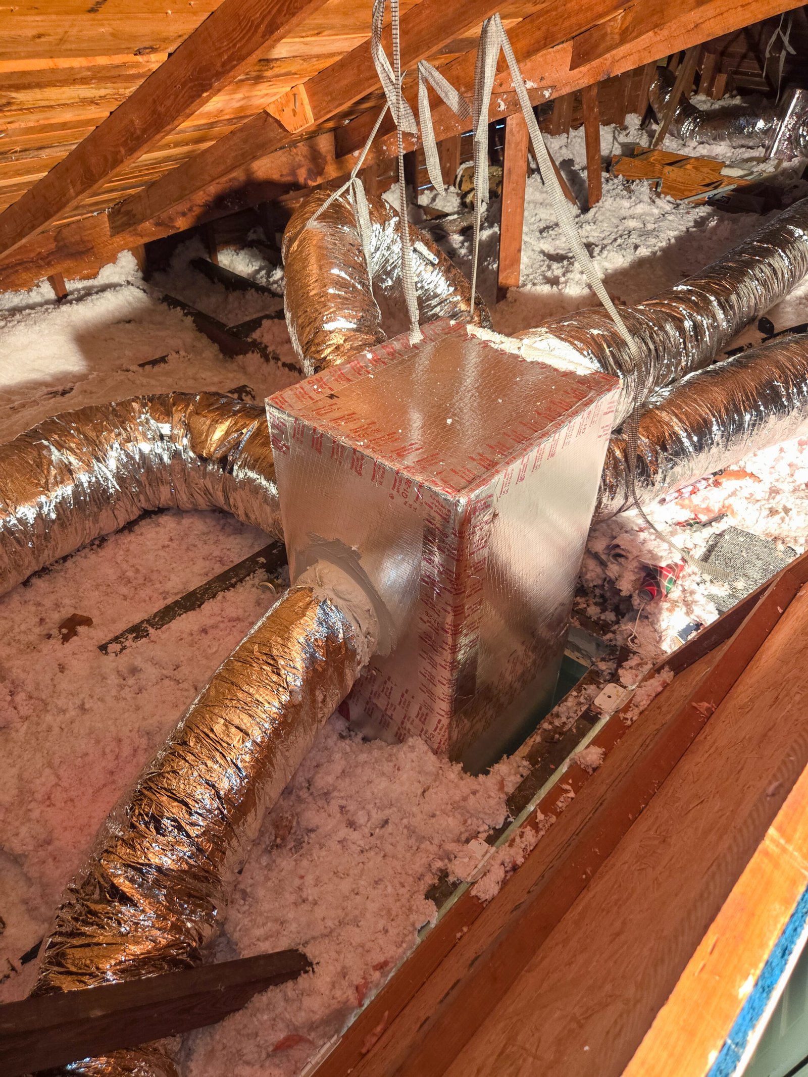 New insulated attic duct plenum and flexible ductwork installed during a duct replacement in Southwest Florida